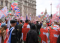 Tommy Robinson's rally sold merch, streamed ads, and promoted a crypto coin — that's the point