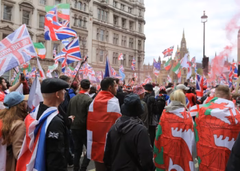 Tommy Robinson's rally sold merch, streamed ads, and promoted a crypto coin — that's the point